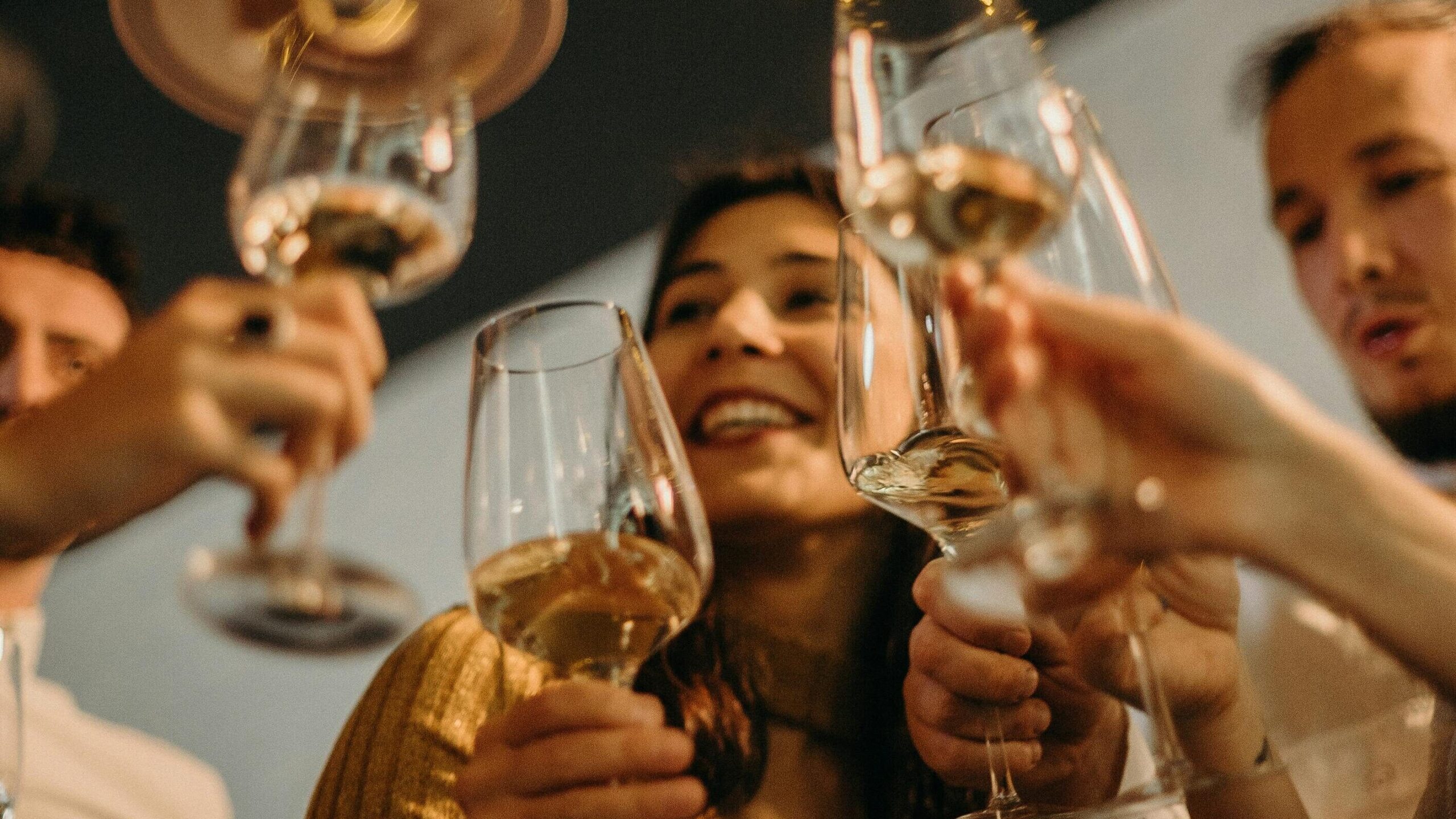 people doing a cheers with wine glasses