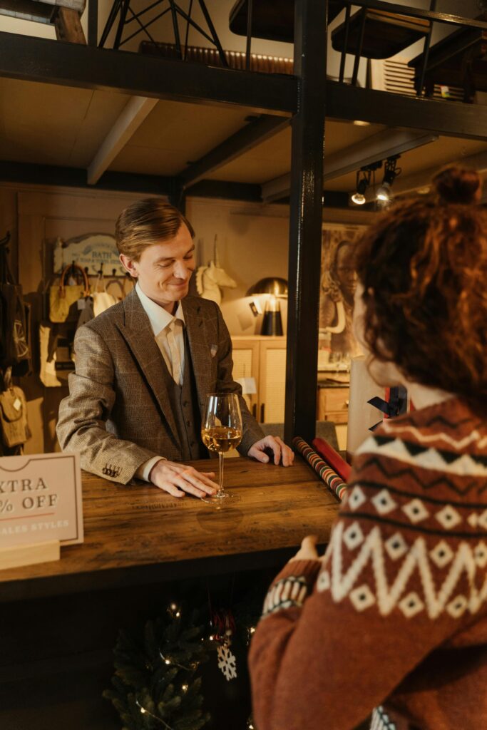 man selling glass of wine to customer