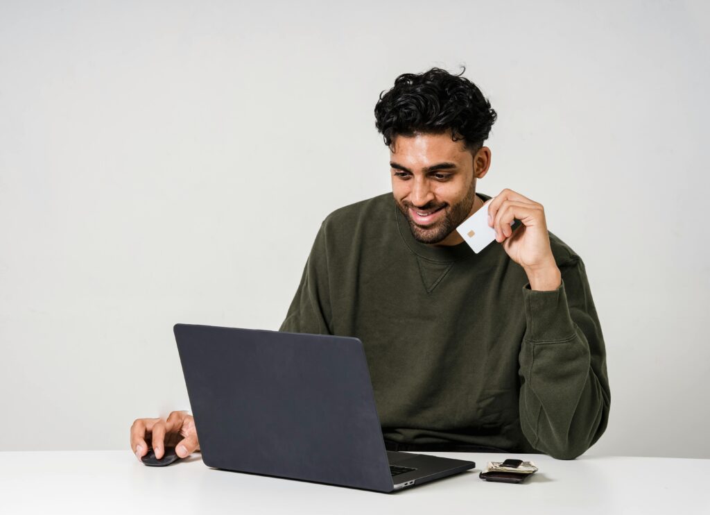 man buying something on his laptop with credit card in hand