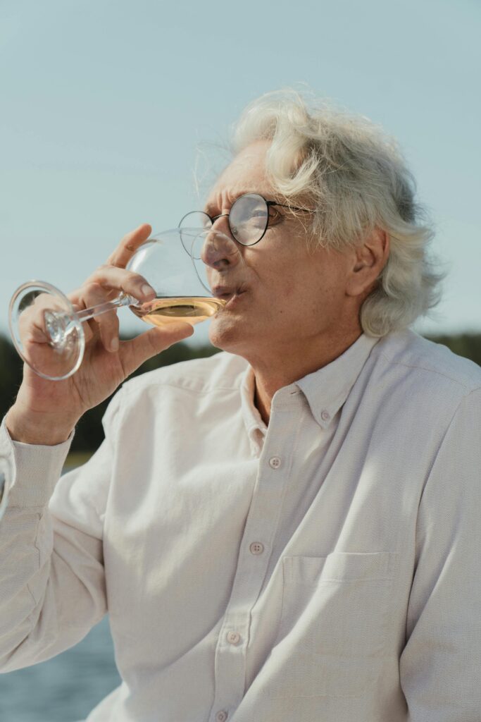old man drinking wine outside enjoying life