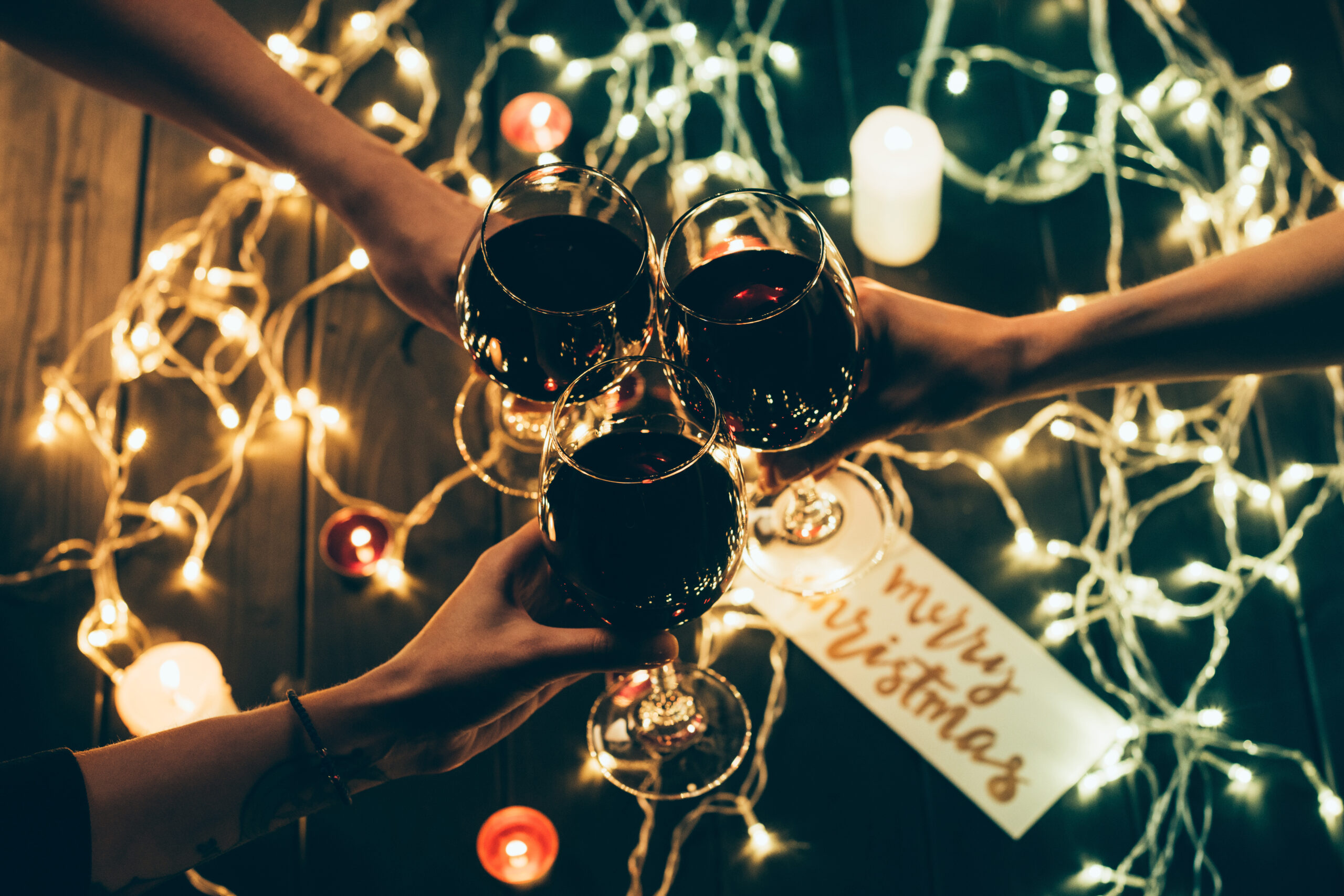 A group of friends cheersing with wine glasses in a lively holiday atmosphere.