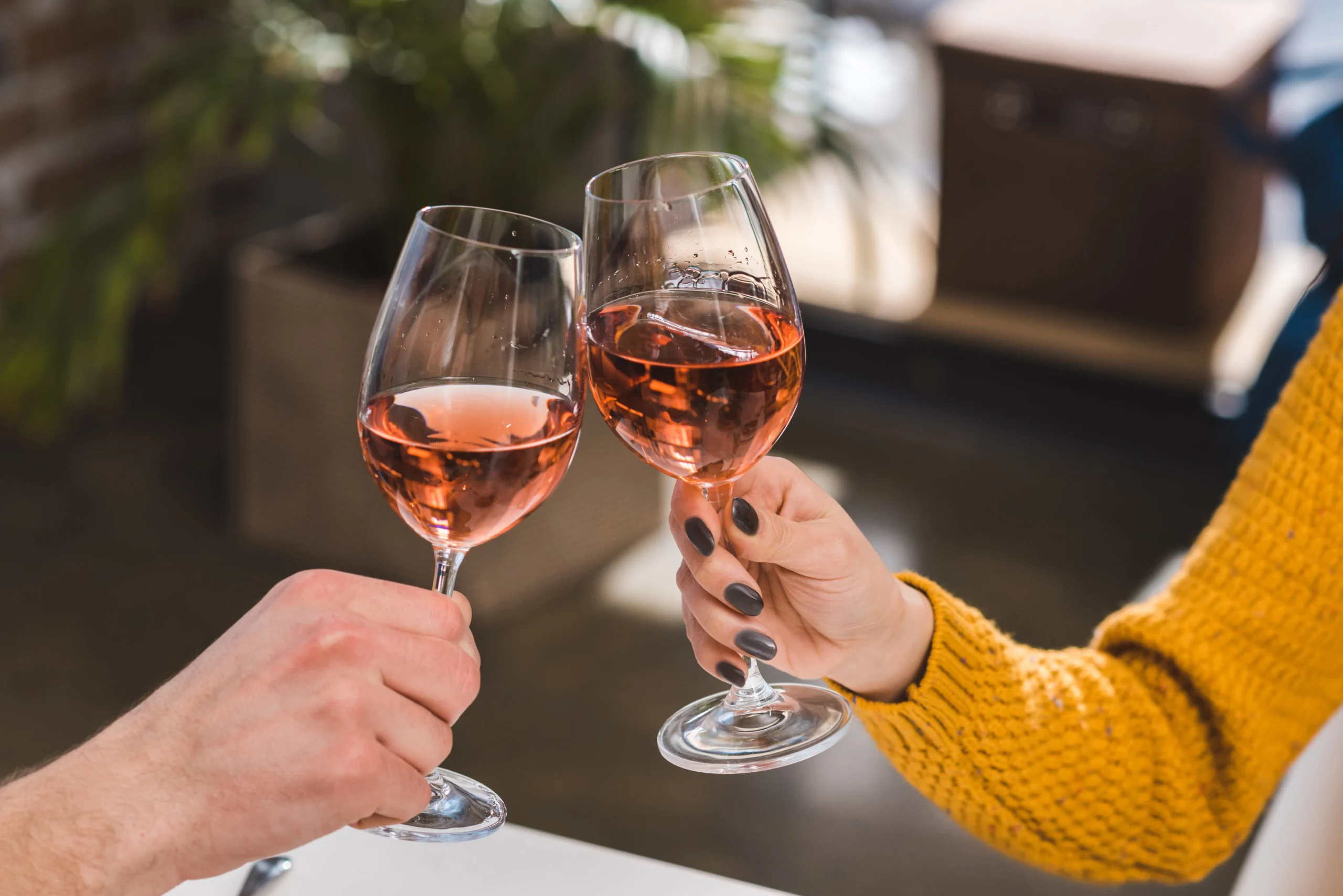 couple clinking glasses of rose wine