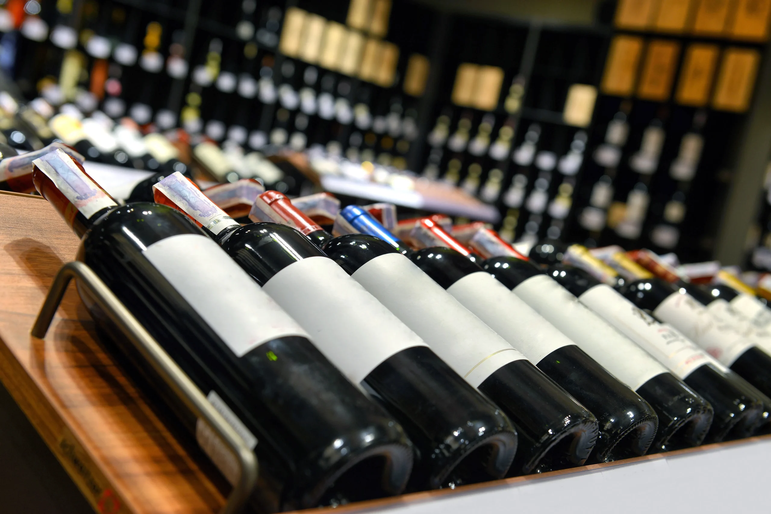 bottles of red wine lined up in a store