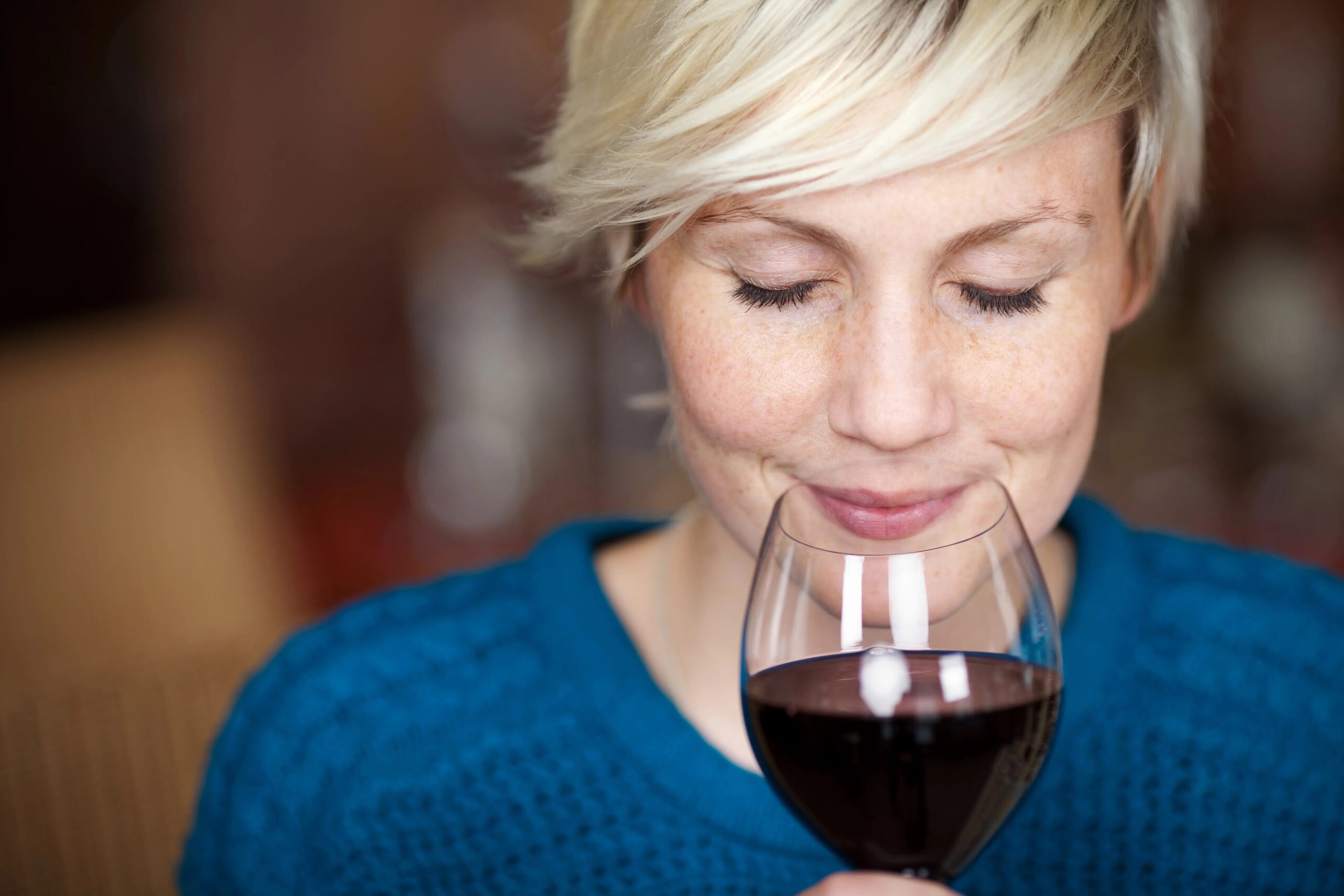 An individual immersed in thought, enjoying a glass of wine in a contemplative setting.